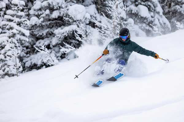 A skier carves a turn in deep snow at Deer Valley, Park City, UT